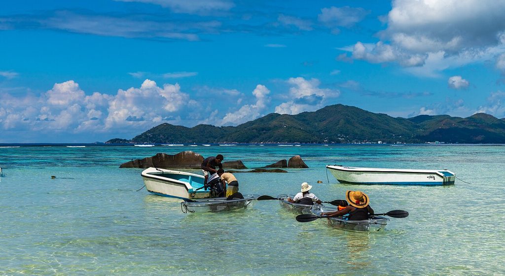 See-through clear kayaks floating on calm turquoise water